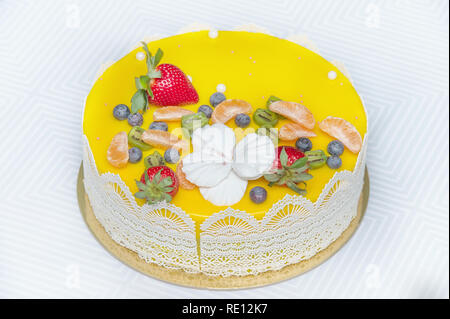 Délicieux gâteau jaune magnifique avec des fruits et des décorations de caramel, avec une surface gelée. Banque D'Images
