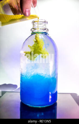 Art shot d'un vase transparent avec une plante à l'eau claire et l'encre bleue en studio avec éclairage Banque D'Images