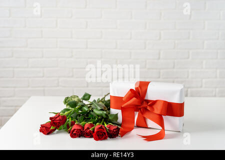 Boîte-cadeau avec bouquet de roses sur le tableau blanc pour la Saint-Valentin Banque D'Images