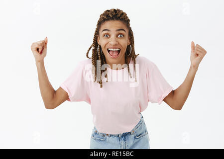 Victoire fille et féliciter ami avec win. Portrait of attractive happy joyeux à peau sombre élégant femelle avec dreads hurler de surprise Banque D'Images
