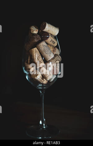 Heap of assorted wine corks en verre de vin sur fond noir Banque D'Images