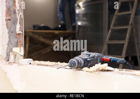 Libre service pour dusty perceuse, perforateur sur fond de réparation, construction, reconstruction, des briques, des escaliers. Installation et concept Banque D'Images