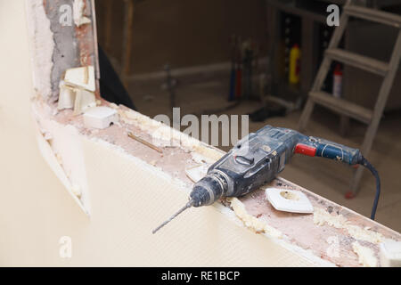 Libre service pour dusty perceuse, perforateur sur fond de réparation, construction, reconstruction, des briques, des escaliers. Installation et concept Banque D'Images