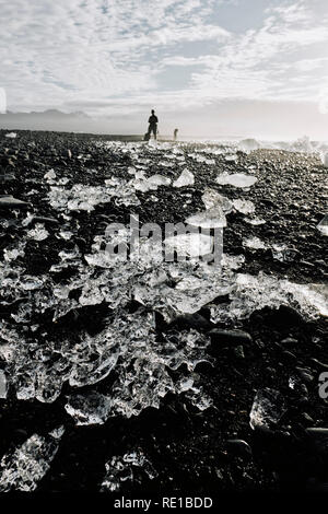 La glace de glacier fondu échouée sur la plage de lave noire de Jokulsarlon dans le sud-est de l'Islande. Banque D'Images