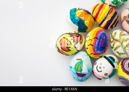 Détail d'oeufs de Pâques peints avec différentes formes, des dessins et des couleurs lumineuses isolées sur fond blanc. Banque D'Images