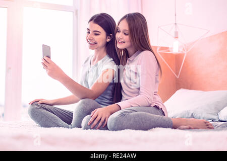 Cheerful friends making sur le téléphone mobile selfies Banque D'Images