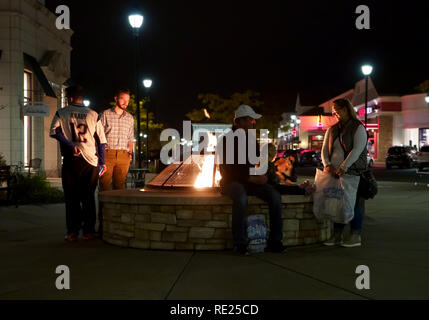 South Windsor CT USA. Nov 2018. Shoppers confortable jusqu'au réchauffement de l' du feu de camp en plein air, Promenade Shops at evergreen Walk mall. Banque D'Images