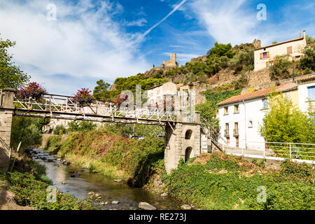 Pont sur ruisseau pittoresque à Lastours, France avec les châteaux dans la distance. Banque D'Images