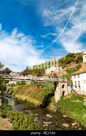 Pont sur ruisseau pittoresque à Lastours, France avec les châteaux dans la distance. Banque D'Images