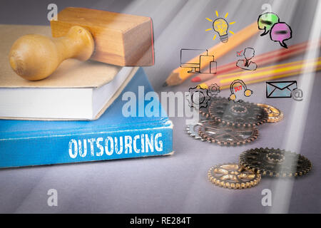 Concept d'externalisation. livre bleu sur une table de bureau gris Banque D'Images