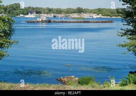 Barge avec cargo sur la rivière, vue de la rive, journée ensoleillée Banque D'Images