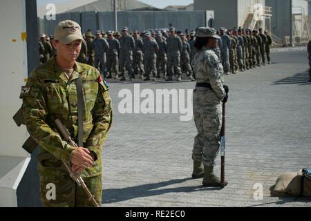 Le déploiement d'un membre de la Royal Australian Air Force sur la garde d'honneur se tient près d'un mémorial en l'honneur de la Coalition Veteran's Day le 11 novembre 2016 dans un endroit inconnu en Asie du Sud-Ouest. De nombreux membres de service portaient des fleurs rouges, souvenir coquelicots, sur leur uniforme au cours de la cérémonie. La tradition a commencé en 1921 à l'honneur des soldats qui sont morts à la guerre. Banque D'Images