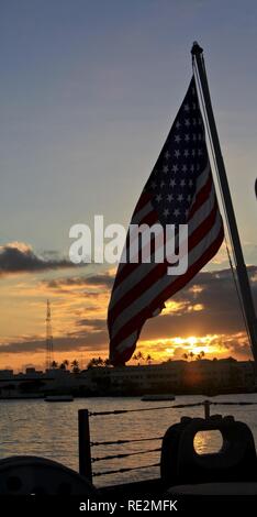 Un drapeau américain est embarqué sur l'USS Missouri durant la Journée des anciens combattants un coucher du soleil à bord du cuirassé Missouri service Memorial à Pearl Harbor, Hawaii, le 11 novembre, 2016. Anciens combattants, accompagnés de leurs amis et membres de la famille, se sont réunis avec les membres en service de toutes les branches de l'armée pour honorer ceux qui ont servi. Banque D'Images