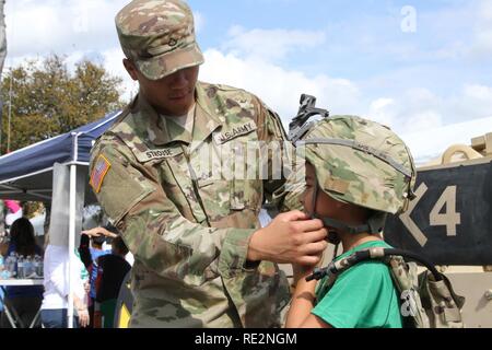 SAN ANTONIO- SPC. Ésaïe Strouse, M2 avec équipage de véhicule de combat Bradley Compagnie Bravo 2-5 Cavalry, aide Dillon Kayastha avec équipement de combat d'enfilage à la 1ère pièce de cavalerie au cours de la 'Armée vs match de football irlandais le 12 novembre 2016. Dillon Kayastha, un natif de New York, rejoint ses parents à l'appui de l'Académie militaire de West Point l'équipe de football. ( Banque D'Images