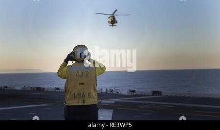 Océan Pacifique-- un membre d'équipage de la Marine américaine signale un UH-1Y venin à terre à bord du USS America (LHA 6), 17 novembre 2016. L'équipage du USS America appuient le transporteur la foudre La preuve du concept de démonstration. Banque D'Images