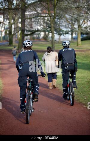 La patrouille policière de vélo dans un parc municipal Banque D'Images