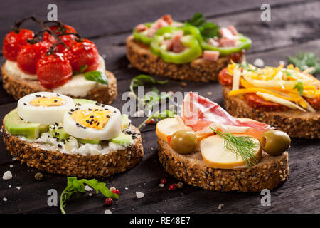 Mini sandwiches alimentaires. Brushetta ou d'authentiques tapas espagnoles traditionnelles pour le déjeuner table. En-cas délicieux antipasti, apéritif, pique-nique sur la partie ou t Banque D'Images