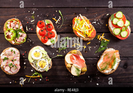 Mini sandwiches alimentaires. Brushetta ou d'authentiques tapas espagnoles traditionnelles pour le déjeuner table. En-cas délicieux antipasti, apéritif, pique-nique sur la partie ou t Banque D'Images