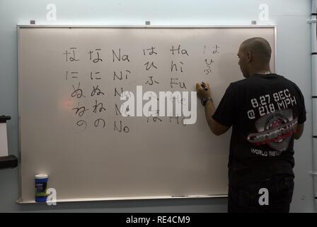 Les pratiques d'un étudiant japonais Hiragana caractères d'écriture sur un tableau blanc au cours d'une classe de langue japonaise de survie le 29 novembre sur Futenma Marine Corps Air Station, Okinawa, Japon. La classe enseignent aux étudiants les principes de base de l'oral et écrit en japonais. Au cours de la leçon, les élèves pratiquent la lecture et l'écriture les trois formes de l'écriture japonaise appelé hiragana, katakana et kanji. Après la lecture et l'écriture de la pratique, les étudiants de tous les jours parler pratiqué des mots et phrases. Banque D'Images