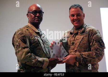 Le Sgt commande. Le major Stephen M. Bodwell, 368Fr. Bn. présente le sergent commande. Le major Anthony Simms avec un bataillon award en signe d'appréciation pour ses paroles d'encouragement à la force du granit aux soldats de la cérémonie d'intronisation des sous-officiers au Camp Arifjan, au Koweït, le 29 novembre 2016. La cérémonie était constituée d'environ 106 soldats du 312e. Co, 389Fr. Co., 461Fr. 475e co, ing. Co., le siège et l'appui de l'avant et de l'Administration centrale Co. Co. de 368Fr. Ne. Banque D'Images