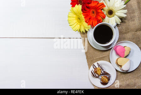 Fleurs romantique avec café et friandises sur la table Banque D'Images