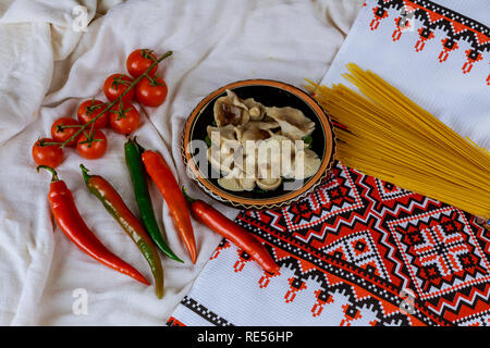 Champignons marinés et rouge poivre tomates rouges, hoot dans une serviette brodée ukrainienne selective Focus style Banque D'Images