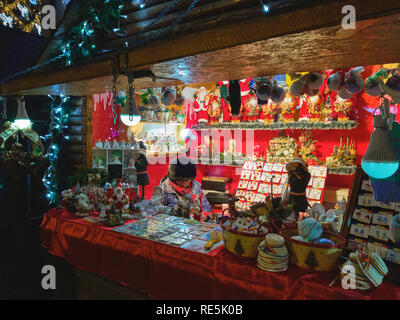 Brasov, Roumanie - 2 décembre 2018 : vendeuse attend les clients à visiter son stand de couleur rouge affichant des décorations traditionnels faits maison durant t Banque D'Images
