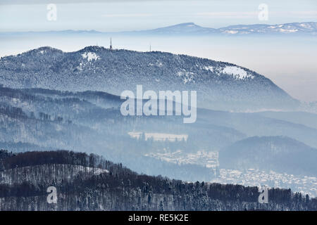 Paysage d'hiver avec vallées Brumeux à la base de la montagne Tampa ville près de Brasov, Roumanie. Banque D'Images