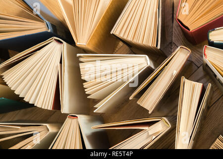 Vieux livres reliés et utilisés, les manuels vu de dessus sur plancher en bois. Le livre et la lecture sont essentiels pour l'amélioration de soi, acquérir des connaissances et s Banque D'Images