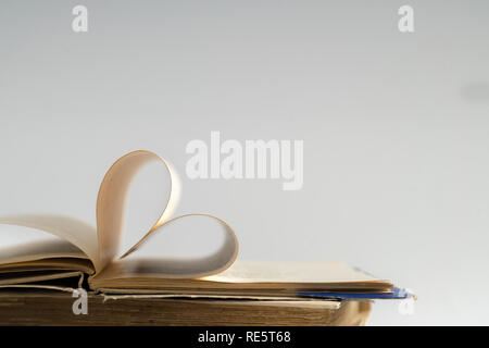 Vieux livre page décorer à forme de coeur pour l'amour de la Saint-Valentin avec arrière-plan flou et esprit vintage. Composition de l'amour, l'apprentissage, s Banque D'Images