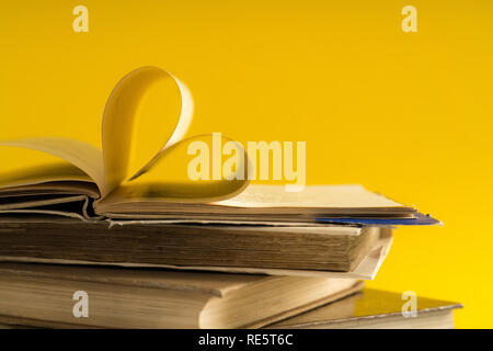 Vieux livre page décorer à forme de coeur pour l'amour de la Saint-Valentin avec arrière-plan flou et esprit vintage. Composition de l'amour, l'apprentissage, s Banque D'Images