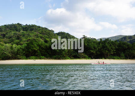 L'homme et la femme en kayak de mer double par une belle plage tropicale, Iriomote jima, Japon Banque D'Images