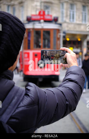 Istanbul - Décembre 2018 : prise de photo du tramway historique Taksim à travers des rues d'Istanbul. Se concentrer sur l'image sur l'écran du smartphone Banque D'Images