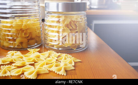 Pâtes en forme d'arcs dispersa d'un bocal en verre. Des pâtes italiennes Banque D'Images