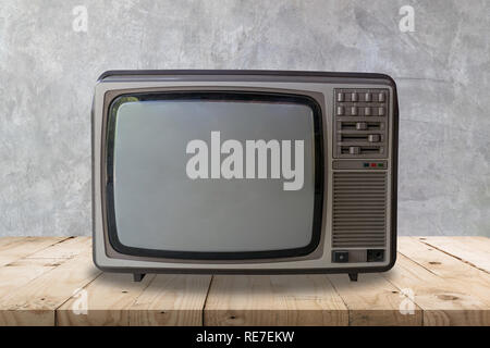 La télévision Vintage sur table en bois et la texture du mur de ciment et l'arrière-plan. Banque D'Images