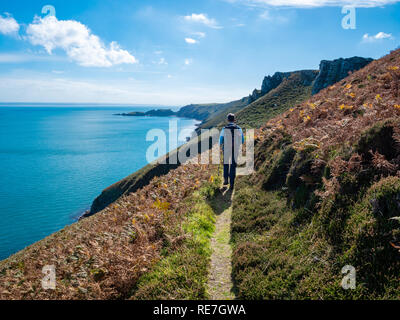 Femme walker sur un chemin en pente raide le long de la côte est de l'île de Lundy dans le chenal de Bristol au large de la côte nord du Devon UK Banque D'Images