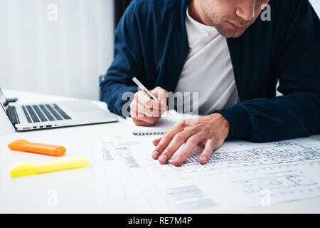 Architect man écrit dans le bloc-notes de nouvelles idées et la préparation du plan de construction. Designer hommes créer un nouveau projet modern home Banque D'Images