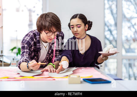 Belle jeune femme designer asiatique conseiller à sa collègue Banque D'Images