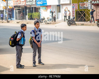 Chikmagalur, Inde- le 20 décembre 2018 : Indian school kids transportant des sacs scolaires attendent le bus scolaire Banque D'Images