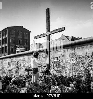 Août 1986, jeune femme à vélo, Peter Fechter memorial, graffitis sur mur de Berlin, Kreuzberg, rue Zimmerstrasse, l'ouest de Berlin, Allemagne, Europe, Banque D'Images