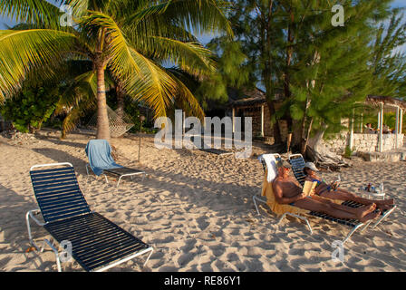 Cat Island, Bahamas. Cottages en front de mer. Hotel Fernandez Bay Village Resort. Les touristes se détendre sur la plage. Banque D'Images