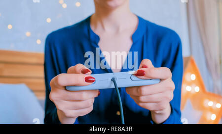 Noël, jeux, vacances, fête et technologie concept - woman holding gamepad et jouer à des jeux vidéos à la maison Banque D'Images