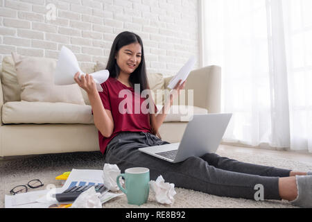 Asian woman freelancer souligner l'émotion tout en travaillant avec un ordinateur portable et des formalités administratives de canapé dans la salle de séjour en chambre.travailler à home concept Banque D'Images