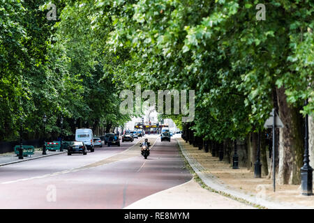 Londres, Royaume-Uni - 21 juin 2018 : Constitution Hill road par la voiture et moto dans la circulation par Buckingham Palace et Green Park avec des arbres en été Banque D'Images