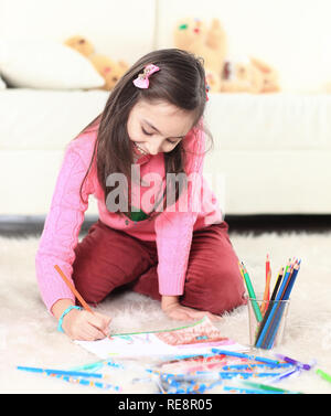 Smiling girl paints avec crayons. photo with copy space Banque D'Images