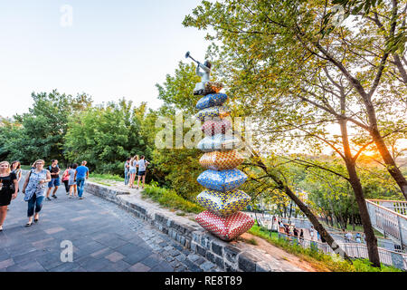 Kiev, Ukraine - le 10 août 2018 : Paysage alley à Kiev capitale pendant le coucher du soleil avec des gens qui marchent sur un trottoir de la rue Park et art sculptures Banque D'Images