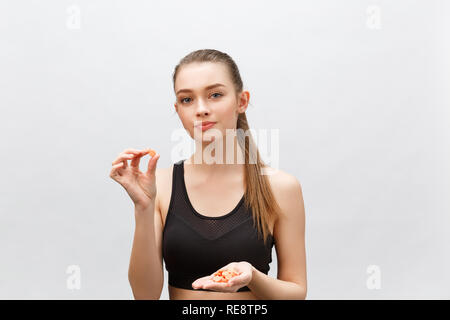 Suppléments, vitamines, Sports, l'alimentation, la nutrition, la saine alimentation, mode de vie. Close up of smiling woman taking remise en forme comprimé avec de l'huile de foie de morue , Oméga-3 vitamine D, E, une des capsules d'huile de poisson Banque D'Images