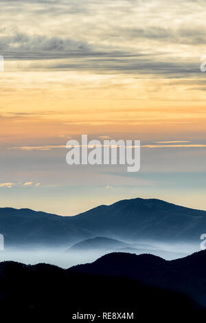 Belle vue sur des montagnes entouré par des nuages et du brouillard au coucher du soleil. Parc National des Abruzzes, Latium et Molise, Italie. Banque D'Images