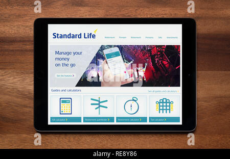 Le site web de la Standard Life est vu sur une tablette iPad, qui repose sur une table en bois (usage éditorial uniquement). Banque D'Images