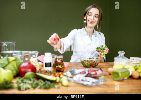 Diététiste femme travaillant sur un régime sain de faire une salade avec différentes matières premières sur le lieu de travail Banque D'Images